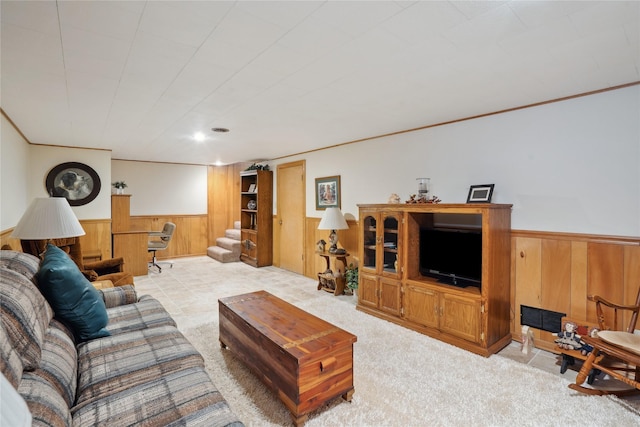 living area with wooden walls, crown molding, and wainscoting