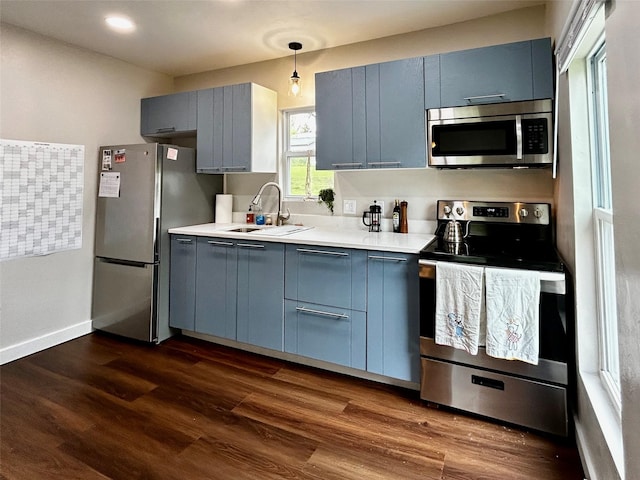 3825 15th St, Des Moines, IA 50313 - kitchen with appliances with stainless steel finishes, a sink, blue cabinets, light countertops, and recessed lighting