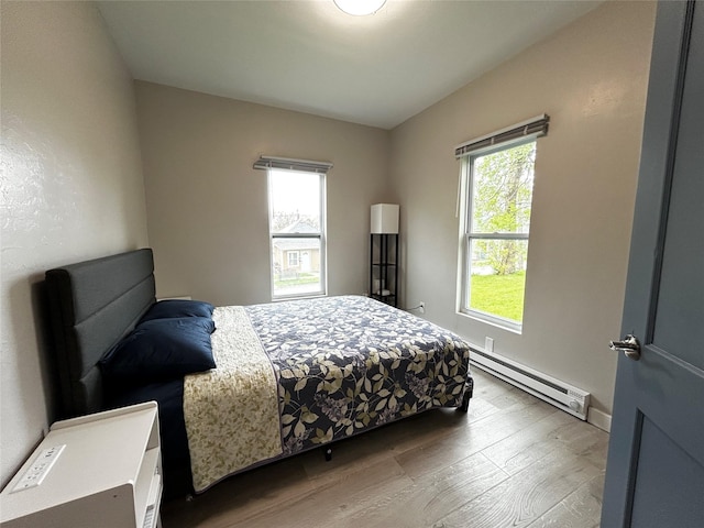3825 15th St, Des Moines, IA 50313 - bedroom with baseboard heating and wood finished floors