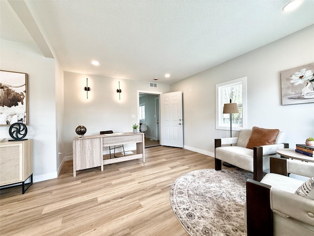 4825 SW 9th St, Des Moines, IA 50315 - living room featuring light wood-style flooring, recessed lighting, baseboards, and a textured ceiling