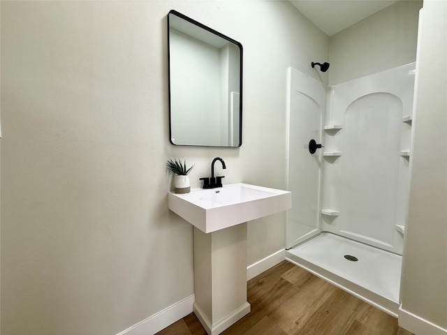 4825 SW 9th St, Des Moines, IA 50315 - full bathroom featuring wood finished floors, a shower, and baseboards