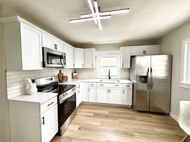 4825 SW 9th St, Des Moines, IA 50315 - kitchen with appliances with stainless steel finishes, a sink, light countertops, and decorative backsplash