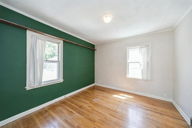 unfurnished room featuring baseboards, ornamental molding, and wood finished floors
