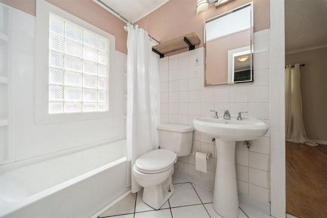 full bath with toilet, tile walls, and shower / bath combo with shower curtain