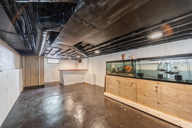 below grade area with baseboards and a bar