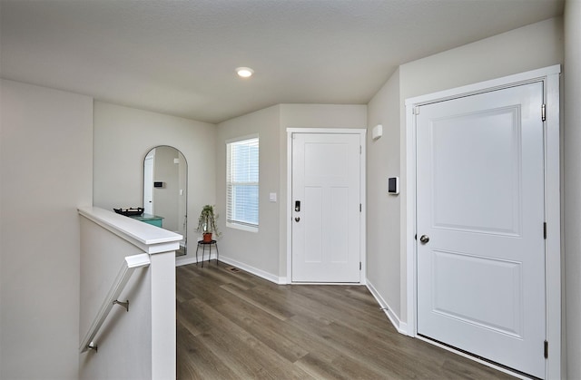 1150 NW Williamsburg Ln, Waukee, IA 50263 - entryway featuring dark wood-style floors, baseboards, recessed lighting, and arched walkways