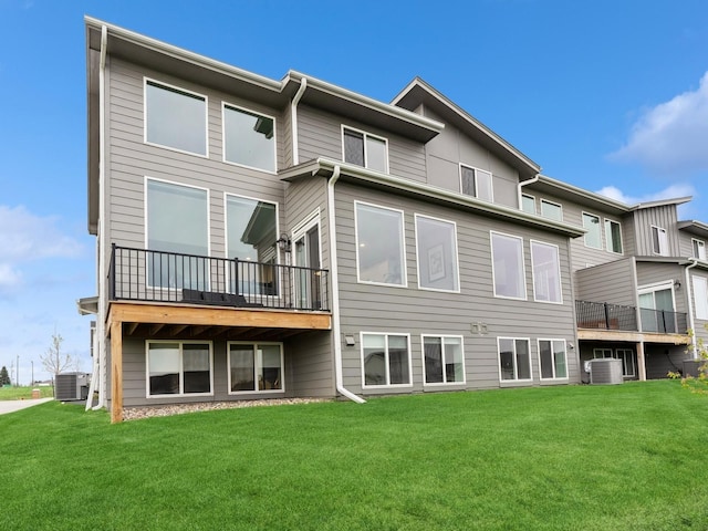 back of property featuring a lawn and central AC