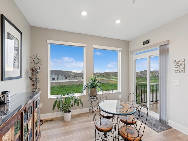 dining space featuring baseboards, light wood-style flooring, and visible vents