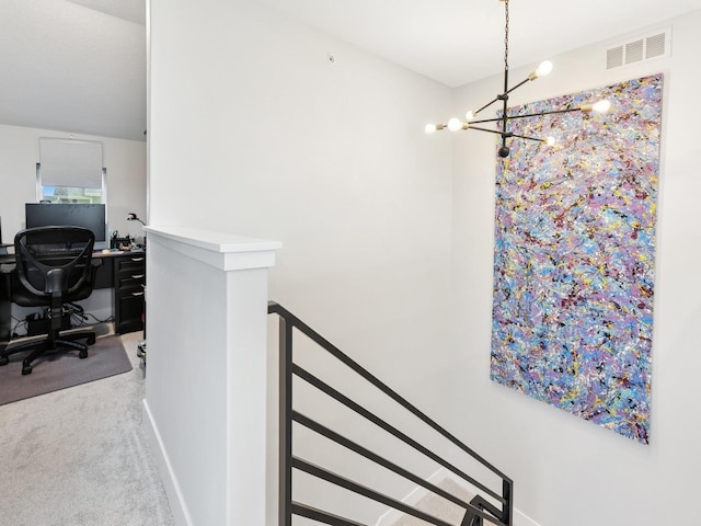 staircase with carpet flooring, visible vents, and a chandelier