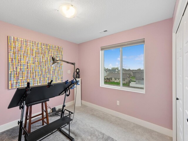 home office with baseboards, a textured ceiling, visible vents, and carpet floors