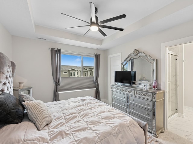 bedroom with marble finish floor, ceiling fan, visible vents, connected bathroom, and a raised ceiling