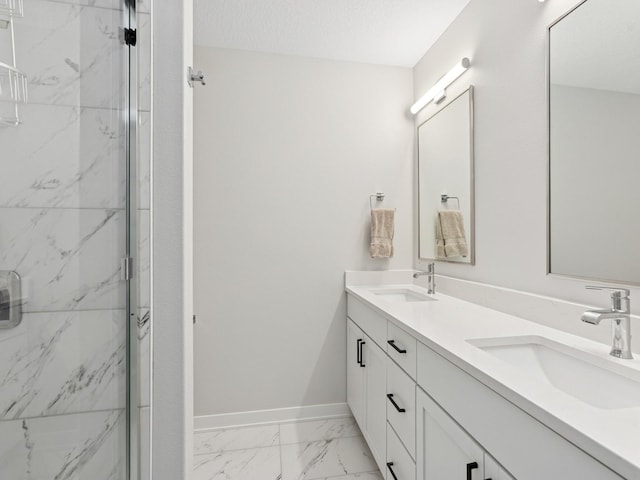 bathroom with a marble finish shower, marble finish floor, baseboards, and a sink