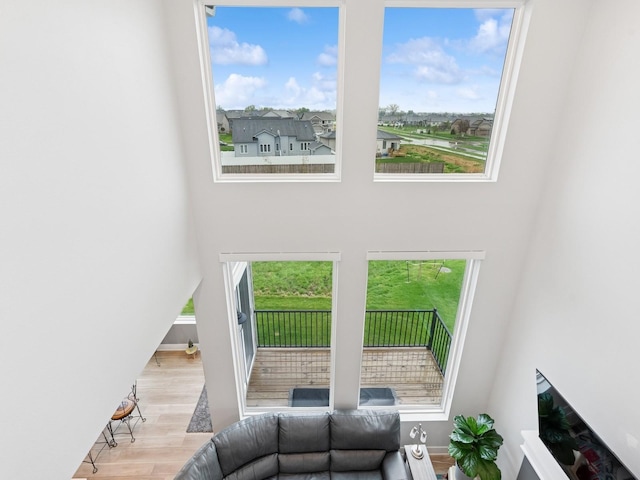living area featuring wood finished floors, baseboards, and a high ceiling