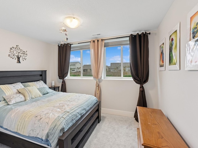 bedroom featuring light colored carpet, baseboards, and visible vents