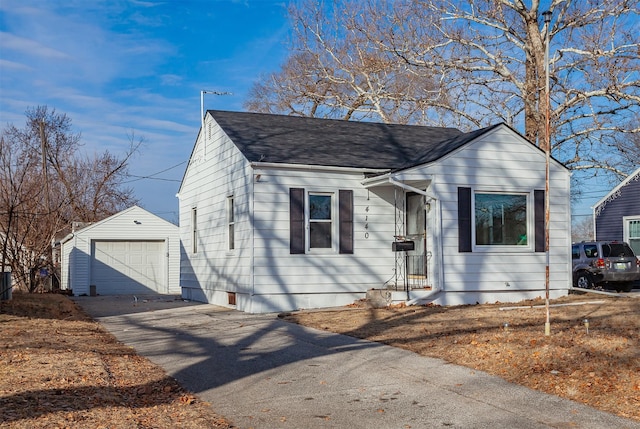 view of front facade with an outdoor structure, driveway, roof with shingles, and a detached garage