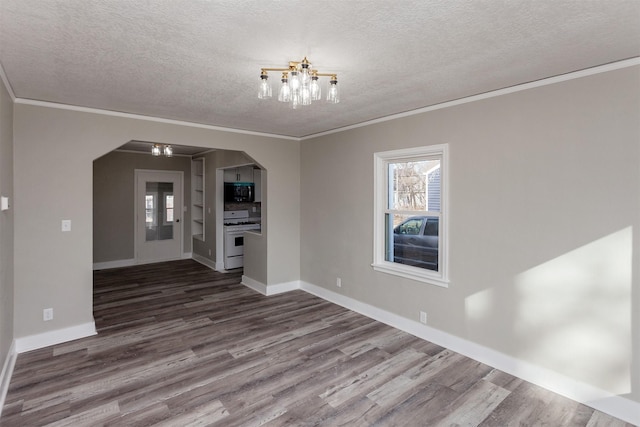 interior space with a textured ceiling, ornamental molding, an inviting chandelier, arched walkways, and dark wood-style floors