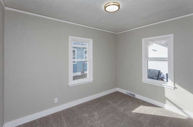 spare room with a textured ceiling, visible vents, crown molding, baseboards, and dark carpet