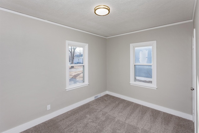 empty room with carpet flooring, ornamental molding, visible vents, and a textured ceiling