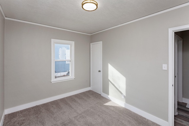 carpeted spare room featuring ornamental molding, a textured ceiling, and baseboards