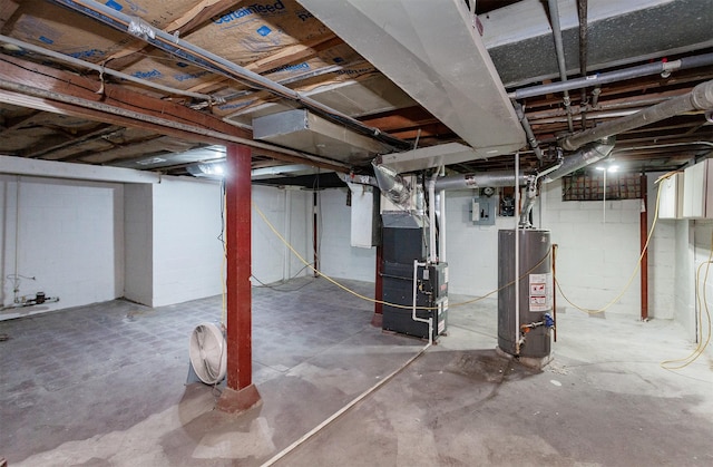 unfinished below grade area featuring concrete block wall, heating unit, electric panel, and gas water heater