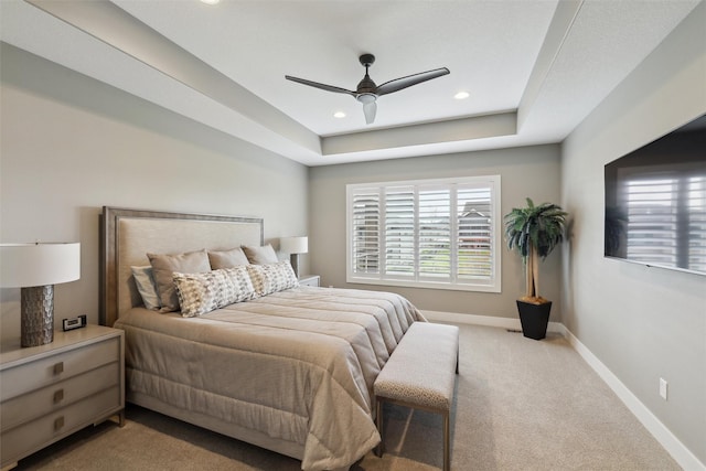 carpeted bedroom featuring baseboards, a raised ceiling, recessed lighting, and a ceiling fan