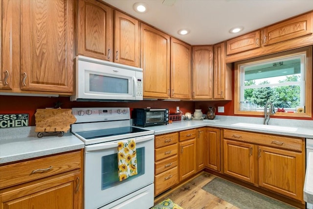 1208 310th Ave, Malcom, IA 50157 - kitchen featuring a sink, white appliances, light wood-type flooring, a toaster, and light countertops