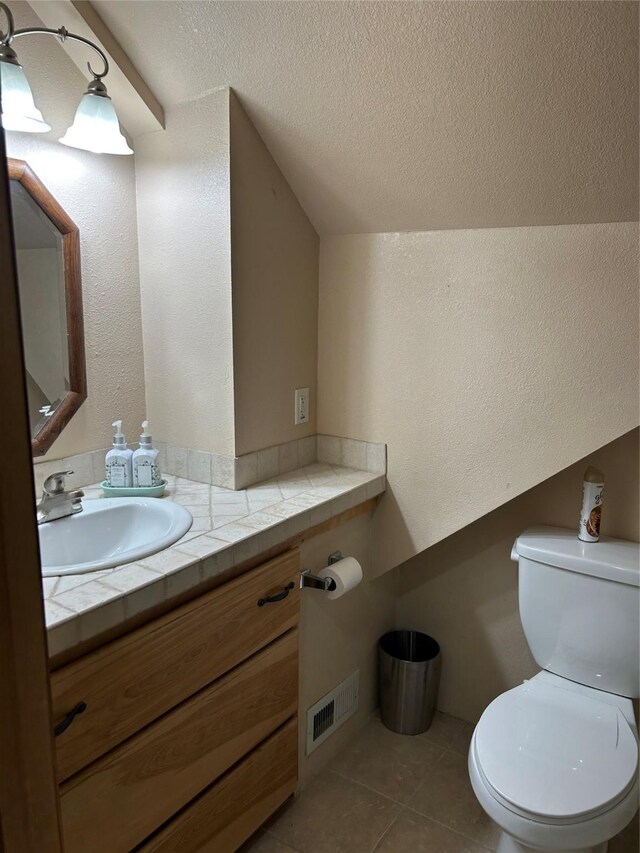 4460 Leo Dr, Panora, IA 50216 - half bathroom featuring vanity, toilet, tile patterned floors, lofted ceiling, and a textured wall