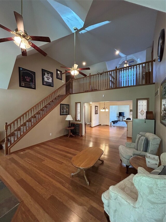 4460 Leo Dr, Panora, IA 50216 - living room with a ceiling fan, high vaulted ceiling, stairs, wood finished floors, and baseboards