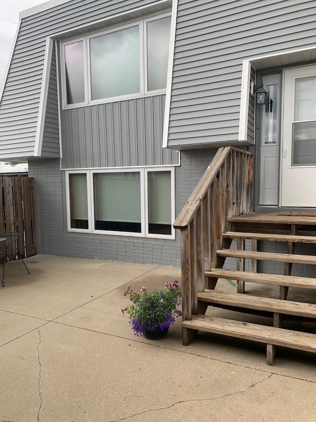 6750 School St Unit 1016, Windsor Heights, IA 50324 - entrance to property featuring brick siding, fence, and a patio area