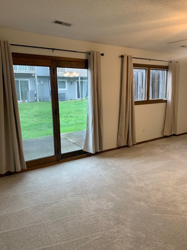 6750 School St Unit 1016, Windsor Heights, IA 50324 - carpeted spare room with baseboards, visible vents, and a textured ceiling