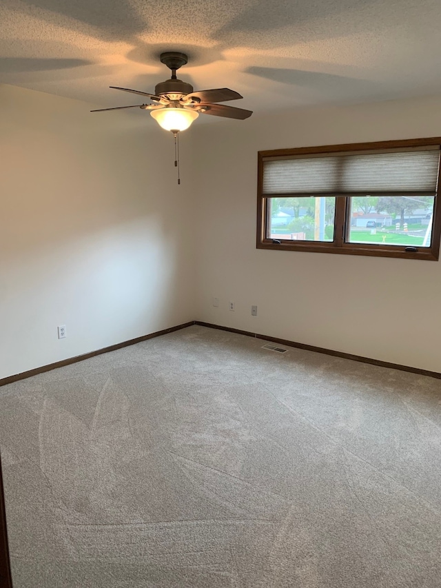 6750 School St Unit 1016, Windsor Heights, IA 50324 - carpeted empty room with a textured ceiling, visible vents, baseboards, and ceiling fan