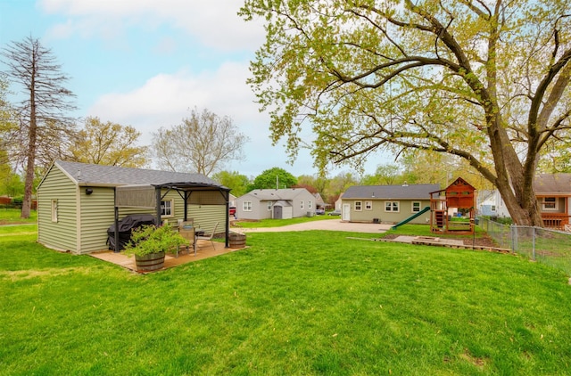 view of yard featuring a patio, a playground, and fence
