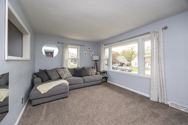 carpeted living room featuring baseboards and visible vents
