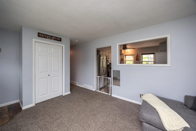 interior space featuring freestanding refrigerator, baseboards, and carpet