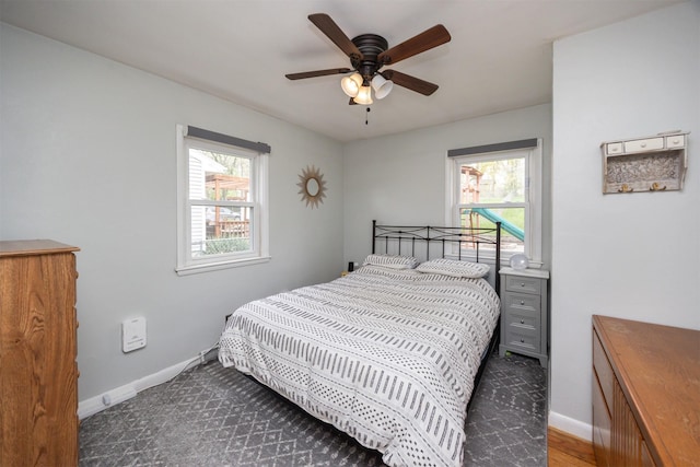 bedroom with multiple windows, baseboards, and a ceiling fan