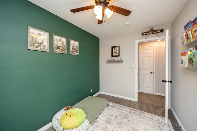 bedroom featuring baseboards, a ceiling fan, and wood finished floors
