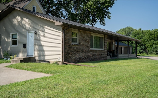 back of property with brick siding and a lawn