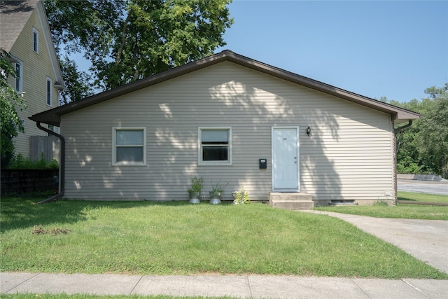 rear view of house with a yard and entry steps