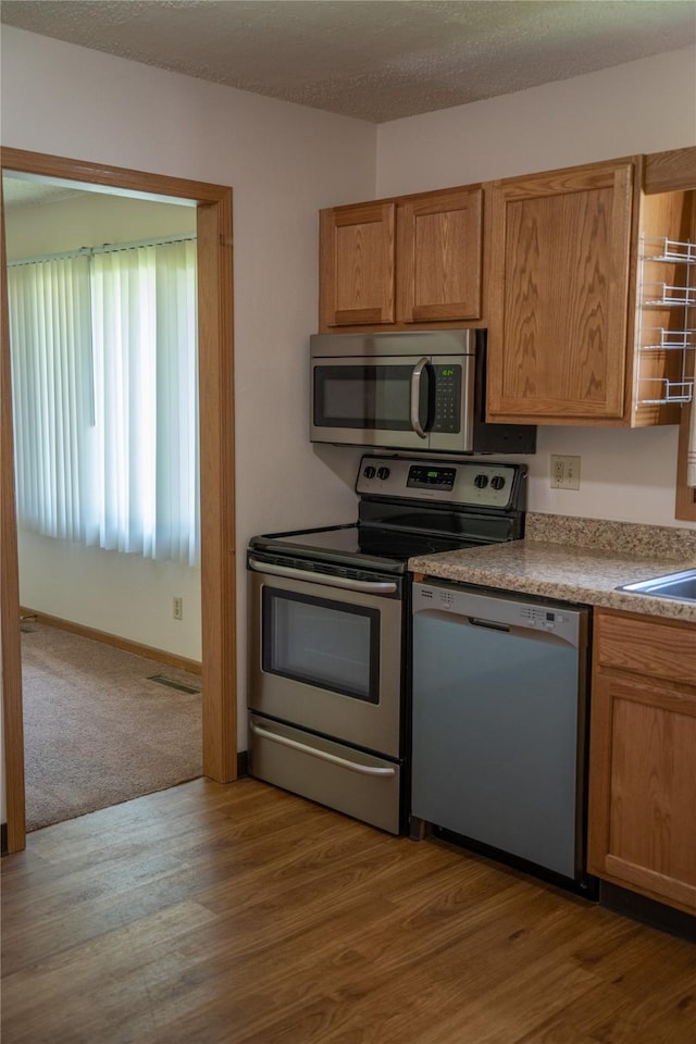 kitchen with wood finished floors and appliances with stainless steel finishes