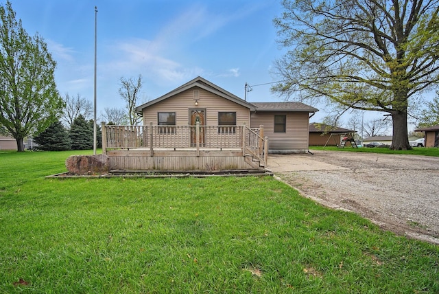 ranch-style home featuring driveway, a wooden deck, and a front yard