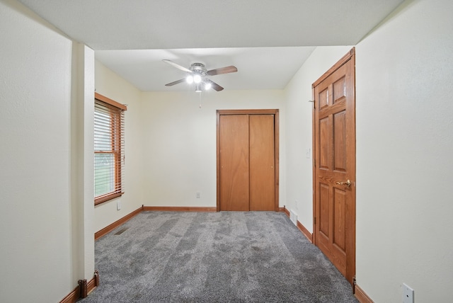 unfurnished bedroom with a closet, visible vents, ceiling fan, carpet flooring, and baseboards