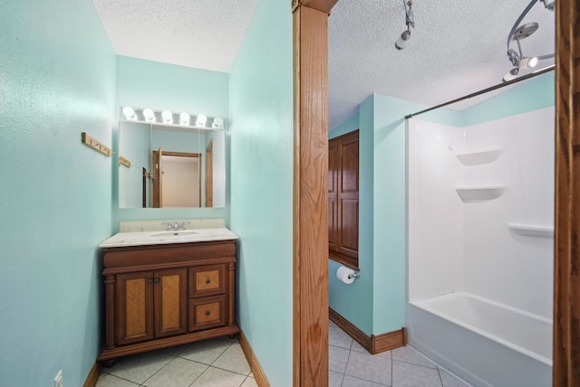 bathroom featuring shower / bath combination, a textured ceiling, baseboards, tile patterned floors, and vanity