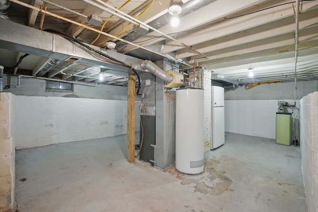 unfinished basement with water heater, heating unit, and freestanding refrigerator