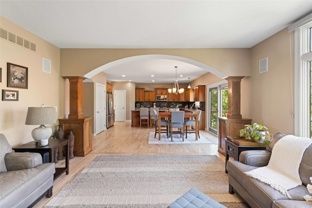 living area with arched walkways, visible vents, and ornate columns