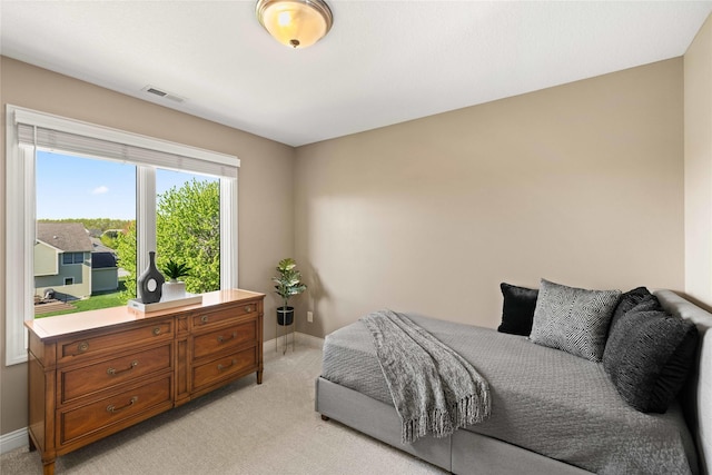 bedroom with baseboards, light carpet, and visible vents