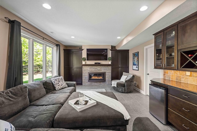 living room with a bar, baseboards, and recessed lighting