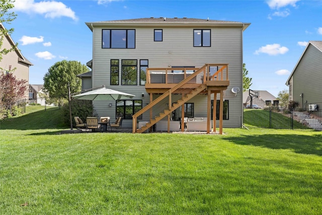 rear view of property featuring a yard, a patio, a deck, stairway, and a fenced backyard