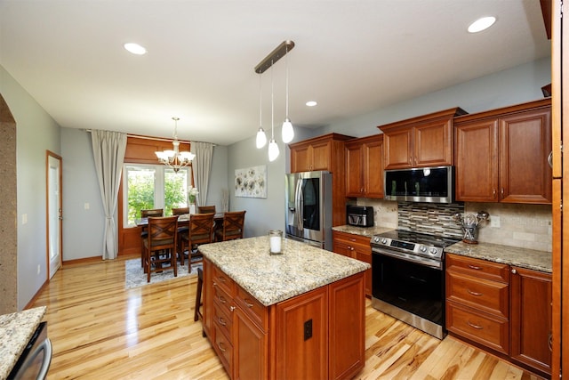 4110 140th St, Urbandale, IA 50323 - kitchen featuring stainless steel appliances, tasteful backsplash, light wood-type flooring, an inviting chandelier, and a center island