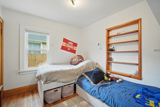 bedroom featuring baseboards and hardwood / wood-style flooring