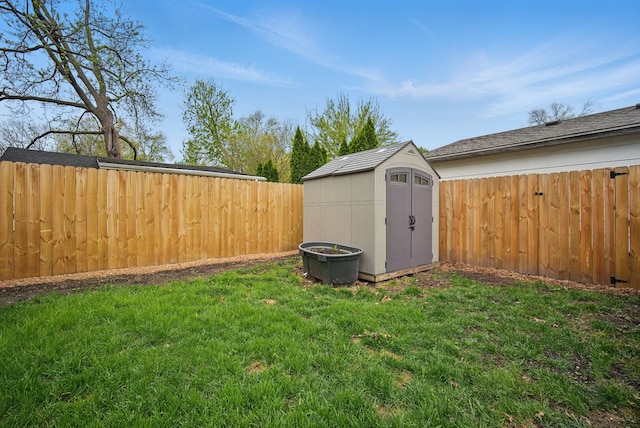 view of yard featuring a storage shed, an outbuilding, and a fenced backyard